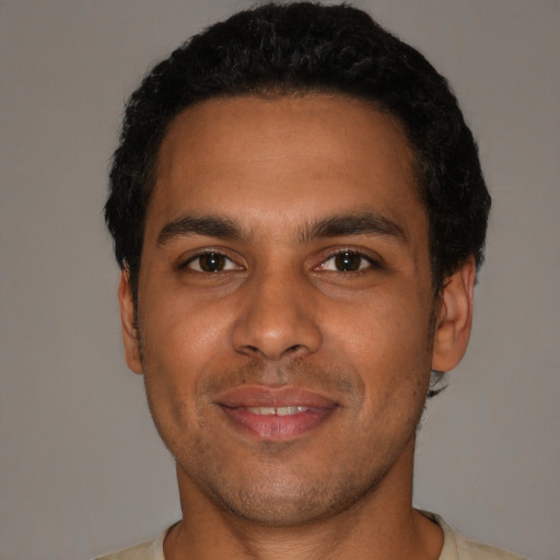 Joyful latino young-adult male with short  brown hair and brown eyes