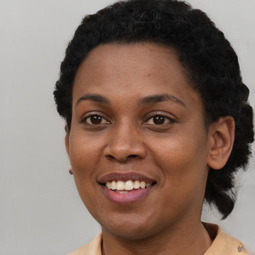 Joyful black young-adult female with short  brown hair and brown eyes
