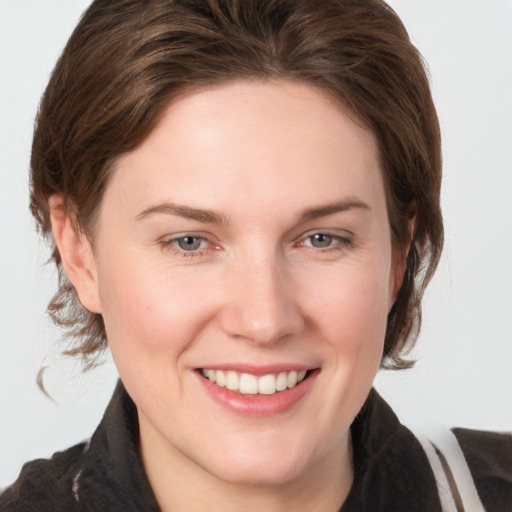 Joyful white young-adult female with medium  brown hair and grey eyes