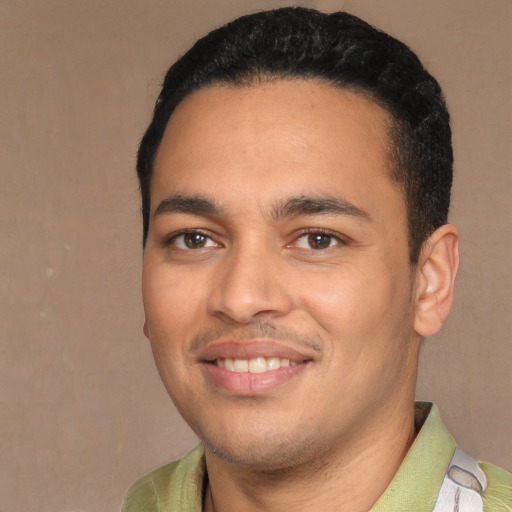 Joyful latino young-adult male with short  brown hair and brown eyes