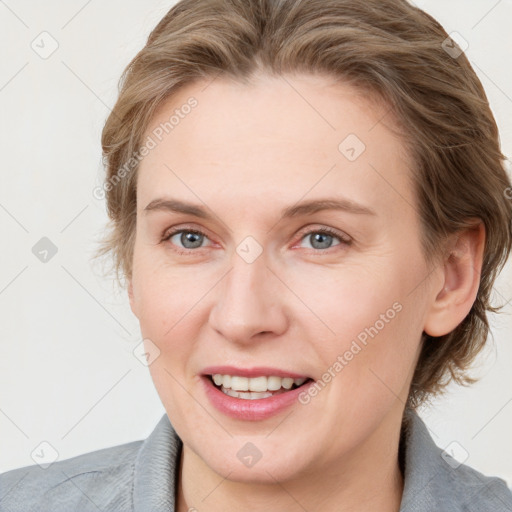 Joyful white adult female with medium  brown hair and blue eyes