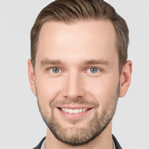 Joyful white young-adult male with short  brown hair and grey eyes