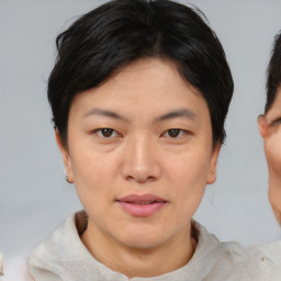 Joyful asian young-adult female with short  brown hair and brown eyes