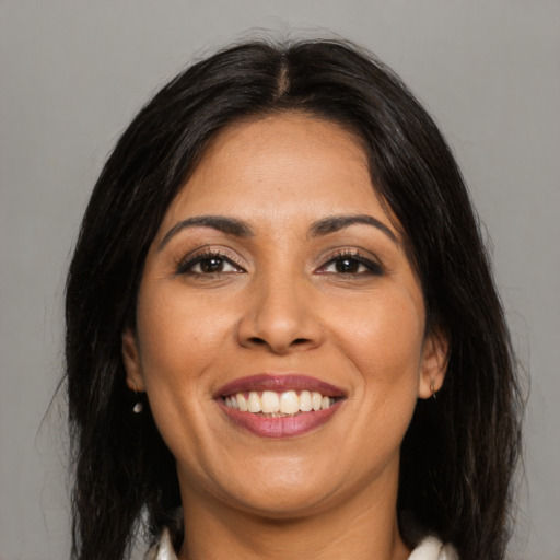 Joyful latino young-adult female with medium  brown hair and brown eyes