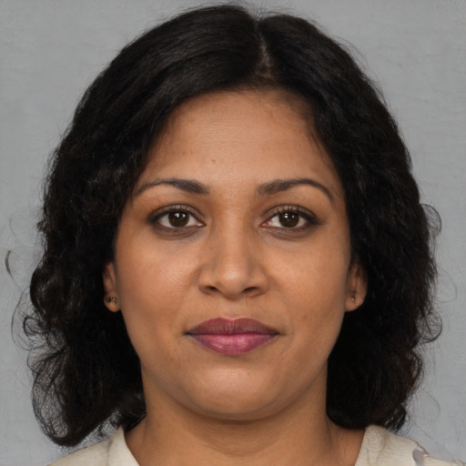 Joyful black young-adult female with long  brown hair and brown eyes