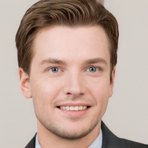 Joyful white young-adult male with short  brown hair and grey eyes