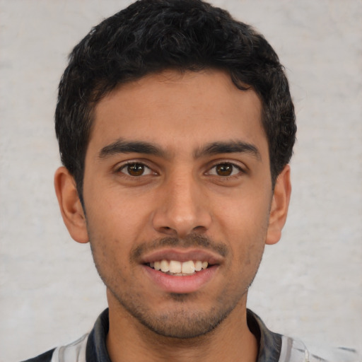 Joyful latino young-adult male with short  brown hair and brown eyes