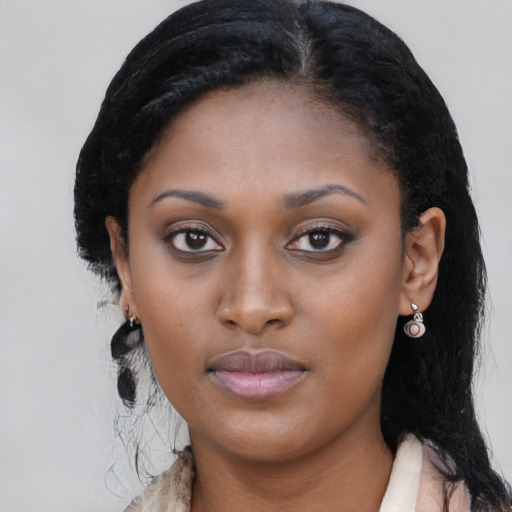 Joyful black young-adult female with long  black hair and brown eyes