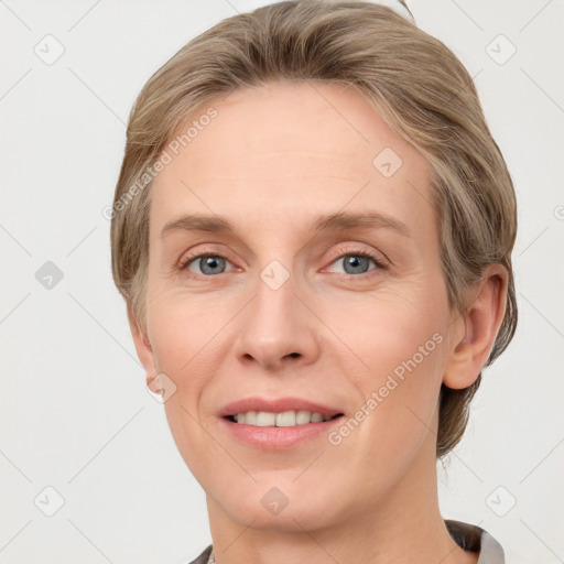 Joyful white adult female with medium  brown hair and grey eyes