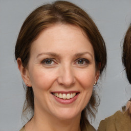 Joyful white adult female with medium  brown hair and blue eyes