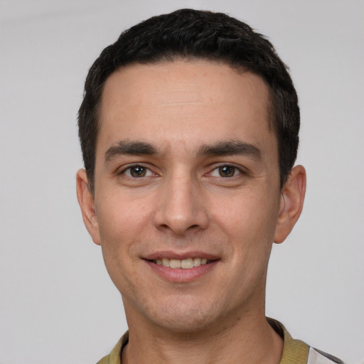 Joyful white young-adult male with short  black hair and brown eyes