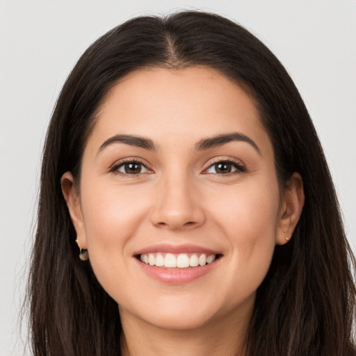 Joyful white young-adult female with long  brown hair and brown eyes