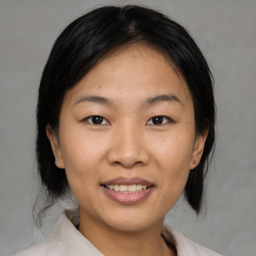 Joyful asian young-adult female with medium  black hair and brown eyes