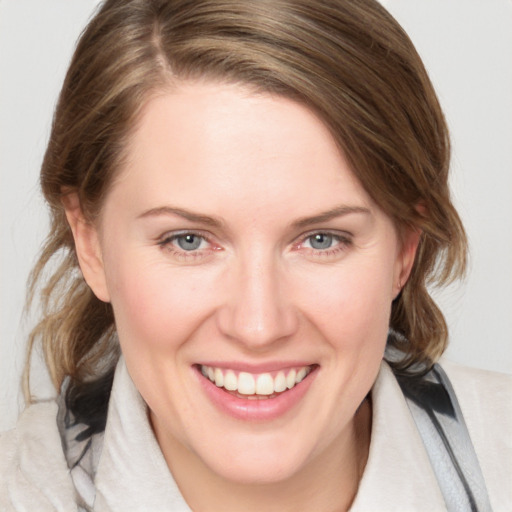 Joyful white young-adult female with medium  brown hair and blue eyes