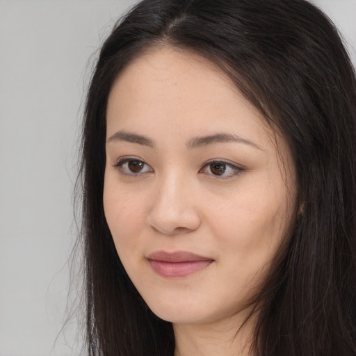 Joyful asian young-adult female with long  brown hair and brown eyes