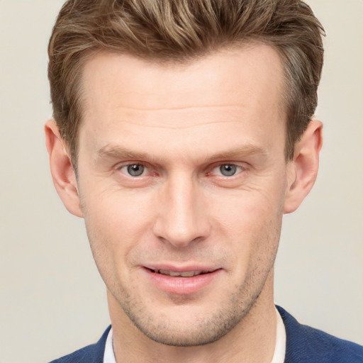 Joyful white adult male with short  brown hair and grey eyes