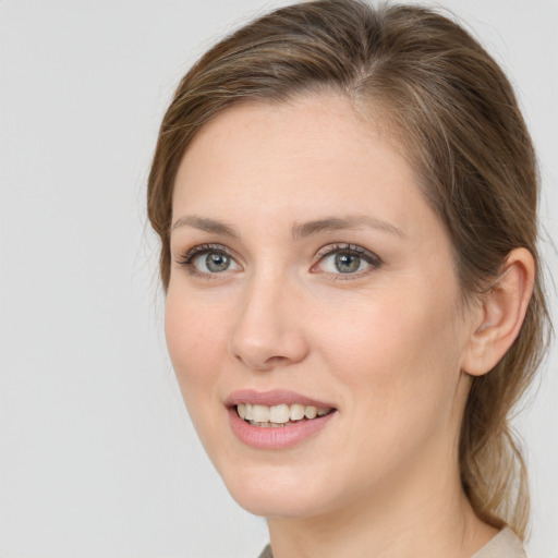 Joyful white young-adult female with medium  brown hair and grey eyes