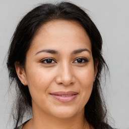 Joyful latino young-adult female with long  brown hair and brown eyes