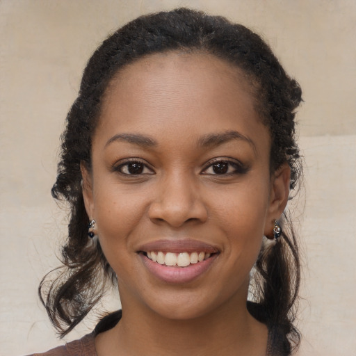 Joyful black young-adult female with long  brown hair and brown eyes
