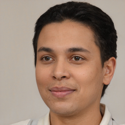 Joyful latino young-adult male with short  black hair and brown eyes