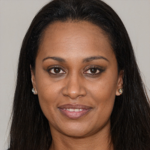 Joyful black young-adult female with long  brown hair and brown eyes