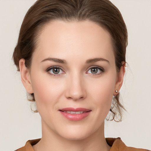 Joyful white young-adult female with medium  brown hair and grey eyes