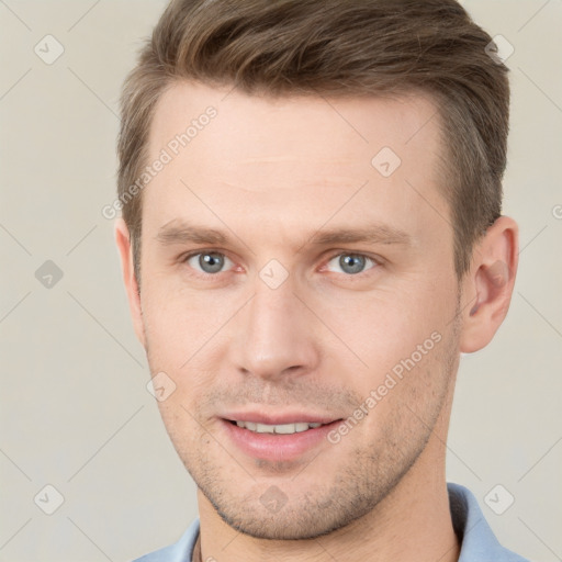 Joyful white young-adult male with short  brown hair and grey eyes