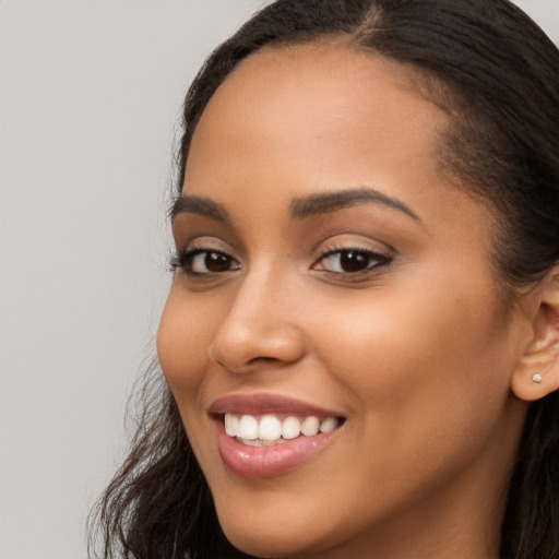 Joyful latino young-adult female with long  brown hair and brown eyes