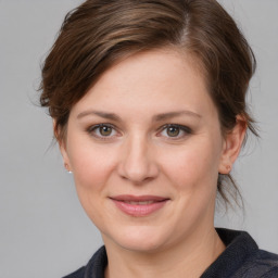 Joyful white young-adult female with medium  brown hair and grey eyes