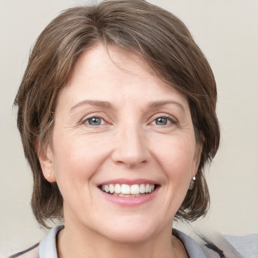 Joyful white adult female with medium  brown hair and grey eyes