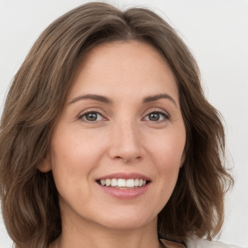 Joyful white young-adult female with medium  brown hair and green eyes