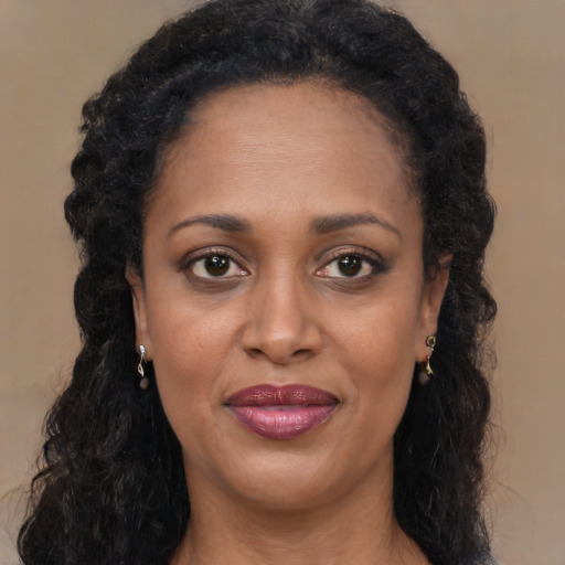 Joyful black young-adult female with long  brown hair and brown eyes
