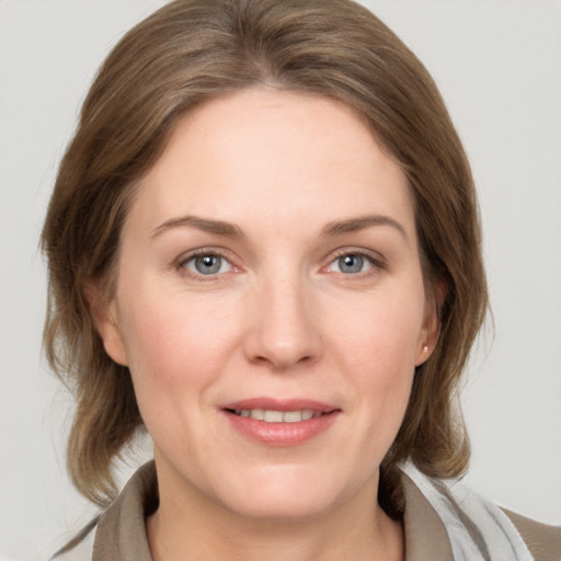 Joyful white adult female with medium  brown hair and grey eyes