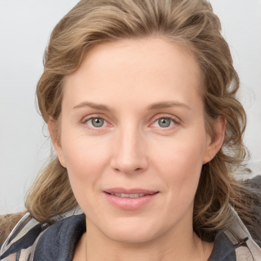 Joyful white young-adult female with medium  brown hair and blue eyes