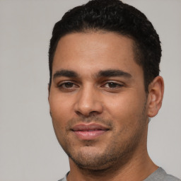 Joyful latino young-adult male with short  black hair and brown eyes