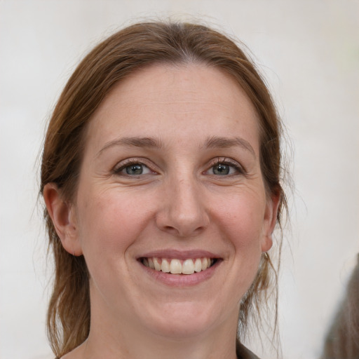 Joyful white adult female with medium  brown hair and grey eyes