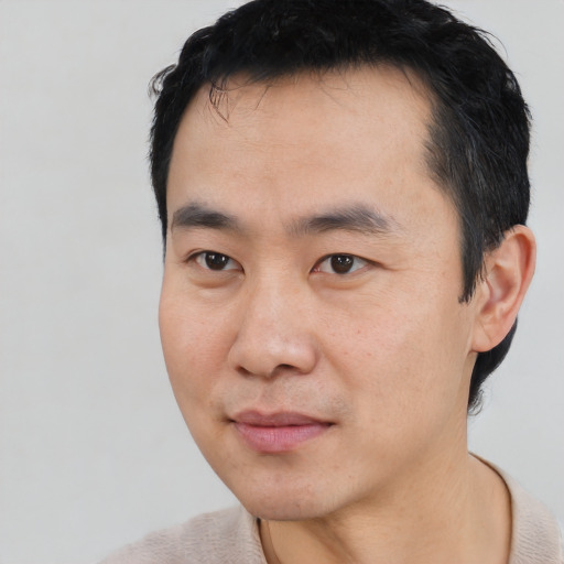 Joyful asian young-adult male with short  black hair and brown eyes
