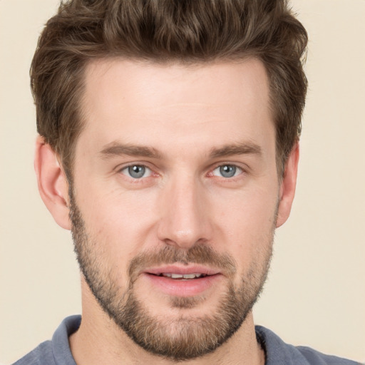 Joyful white young-adult male with short  brown hair and grey eyes