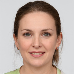 Joyful white young-adult female with medium  brown hair and grey eyes