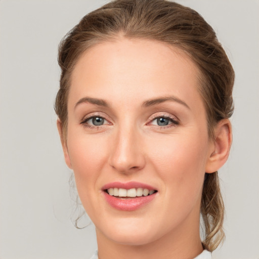 Joyful white young-adult female with medium  brown hair and grey eyes