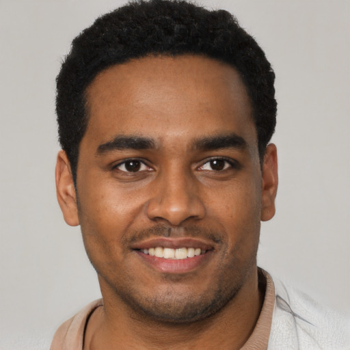 Joyful black young-adult male with short  black hair and brown eyes