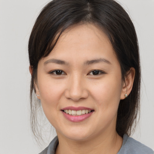 Joyful asian young-adult female with medium  brown hair and brown eyes