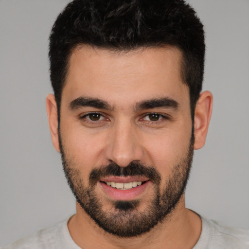 Joyful white young-adult male with short  black hair and brown eyes