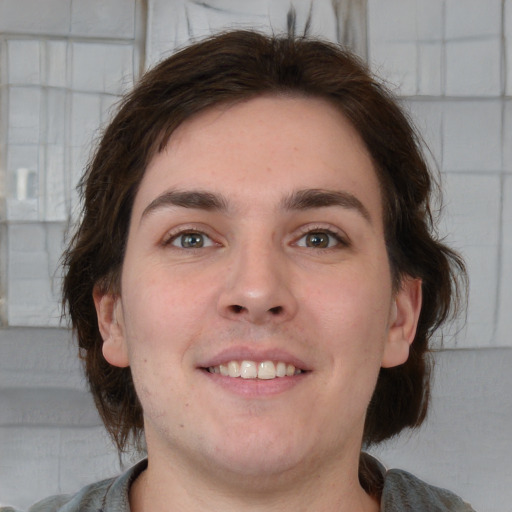 Joyful white young-adult male with medium  brown hair and grey eyes