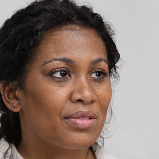 Joyful black adult female with medium  brown hair and brown eyes