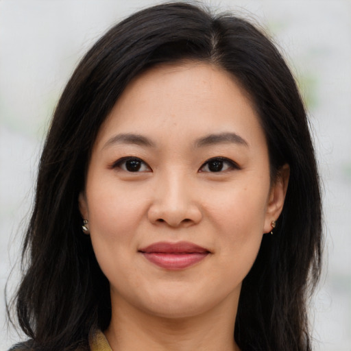 Joyful asian young-adult female with long  brown hair and brown eyes