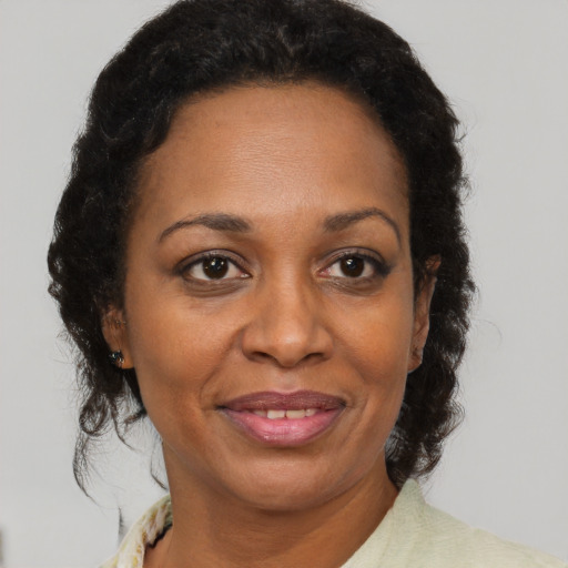 Joyful black adult female with short  brown hair and brown eyes