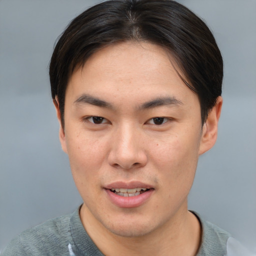 Joyful asian young-adult male with short  brown hair and brown eyes