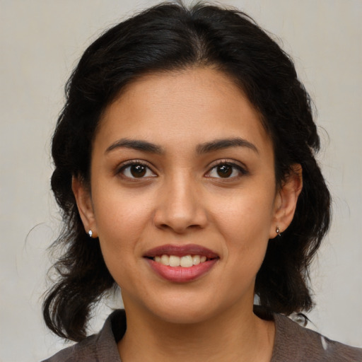 Joyful latino young-adult female with medium  brown hair and brown eyes