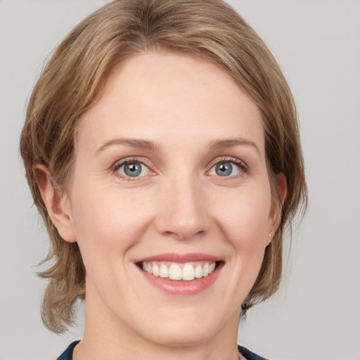 Joyful white young-adult female with medium  brown hair and blue eyes